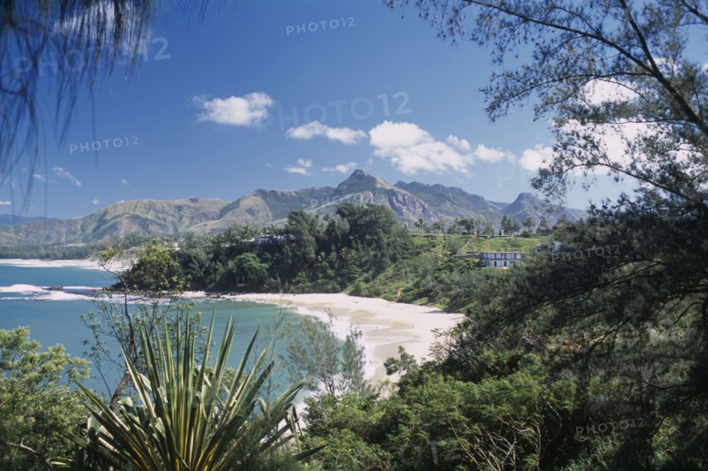 MADAGASCAR, Fort Dauphin, Libanona Beach with view across plants and vegetation towards sandy stretch of beach and sea with mountains in the distance