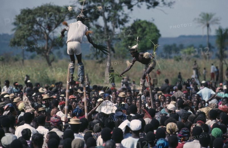 CONGO, Gungu, Bapende stiltwalkers amongst crowd at Gungu festival.