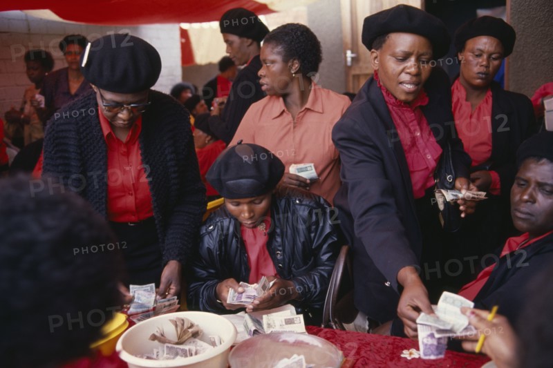 SOUTH AFRICA, Gauteng, Alexandra Township, "Female members of Burial Society or Stokvel counting money.  Funerals are seen as an important part of culture and tradition and are costly, often lasting several days."