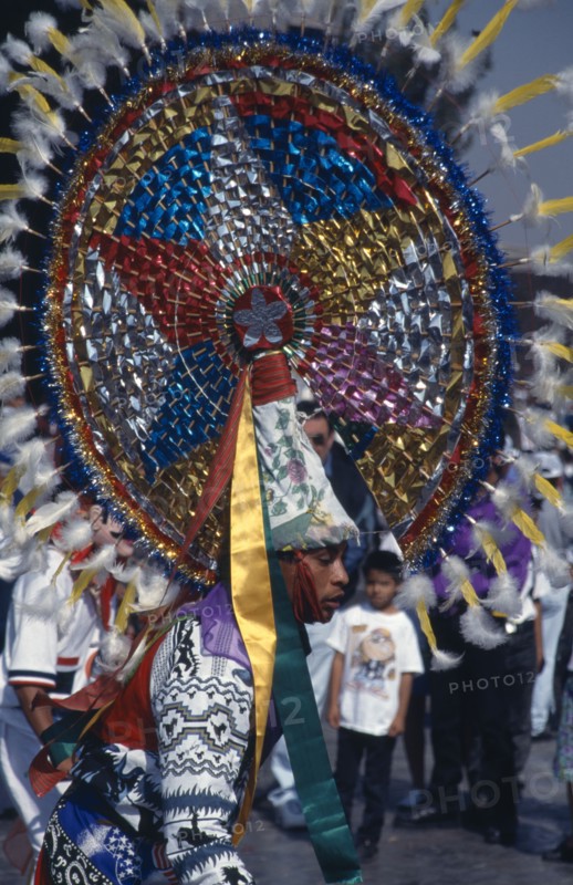 MEXICO, Mexico City, Our Lady of Guadaloupe Festival. Indian male dancer with large colorful headdress celebrating outside the Basilica of Guadaloupe