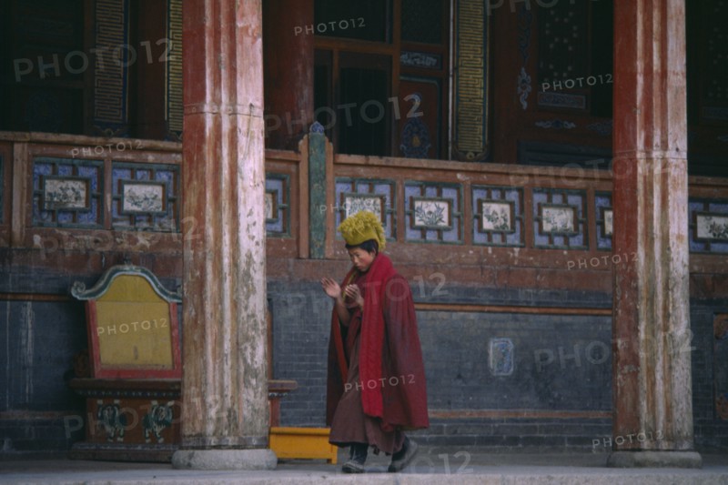 CHINA, Qinghai Province, Taer Lamasery, Tibetan Yellow Hat Buddhist monk calling other monks to prayer.
