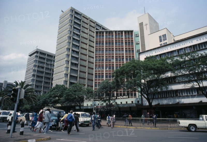 KENYA, Nairobi, "Downtown Nairobi with people crossing road, waiting traffic and high rise buildings."