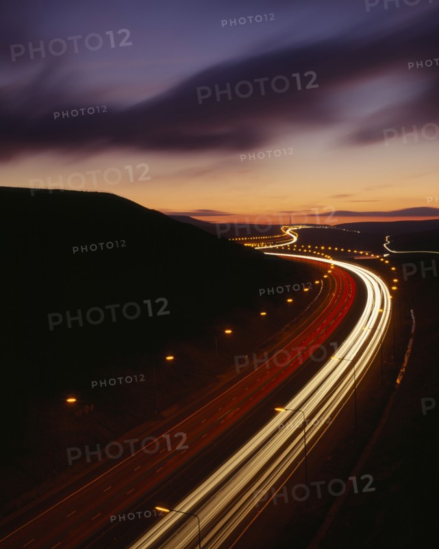 TRANSPORT, Traffic, Motorway, M62 Motorway. Elevated view over traffic in motion blur with light trails seen in late evening with a dramatic cloud formation