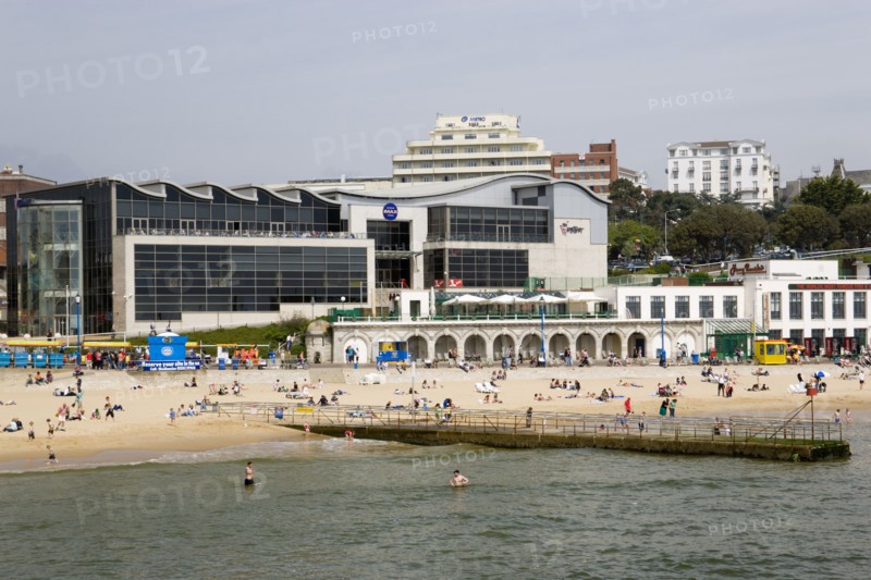ENGLAND, Dorset, Bournemouth, The Imax Complex on the seafront with people on the beach and in the water by a small pier jetty