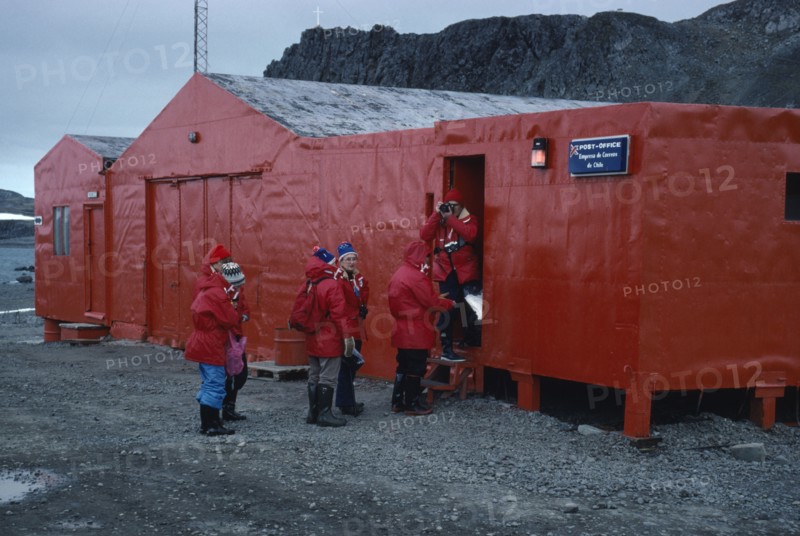 ANTARCTICA, King George Island, Teniente Marsh Station. Tourists wearing red jackets outside Post Office