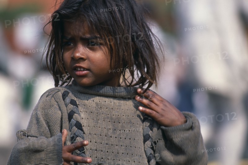 INDIA, Delhi, "Portrait of young street girl wearing dirty,oversized jumper.  Rtnd 2 VKB 15/5/2009"