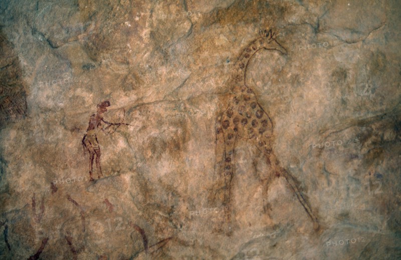 LIBYA, Wadi Auis, Detail of prehistoric rock art depicting giraffe and hunter.