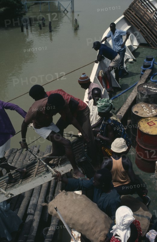 GAMBIA, Transport, People boarding boat on the River Gambia.