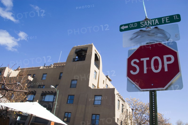 USA, New Mexico, Santa Fe, Stop sign on the Old Santa Fe Trail beside an adobe Pueblo Revival style building