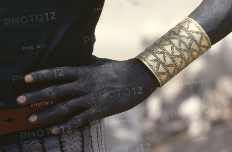 SUDAN, Tribal People, Cropped shot of Dinka man wearing brass bracelet decorated with abstract design.