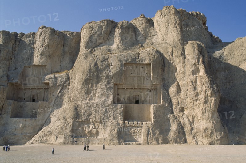 IRAN, Fars Province, Naghshe Rostam , Naghshe Rostam near Persepolis. Achaemenian Tombs with visitors walking around