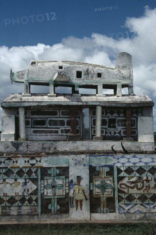 MADAGASCAR, Art, Part view of Mahafaly highly decorated tomb with carved effigy of aeroplane on roof.