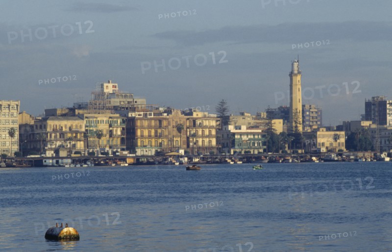 EGYPT, Port Said, City on coast where the Suez Canal meets the Mediterranean and founded in 1859 to house canal workers.  City and Suez Canal at dusk.