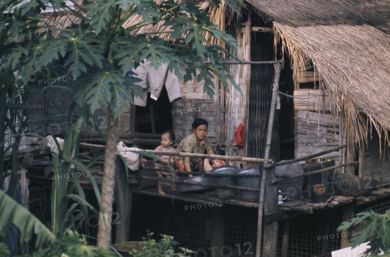 LAOS, People, Family, Mother bathing children outside stilt house