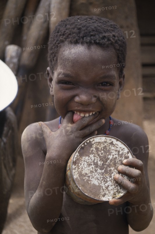 GHANA, North, People, Portrait of small child pulling face with fingers in mouth.