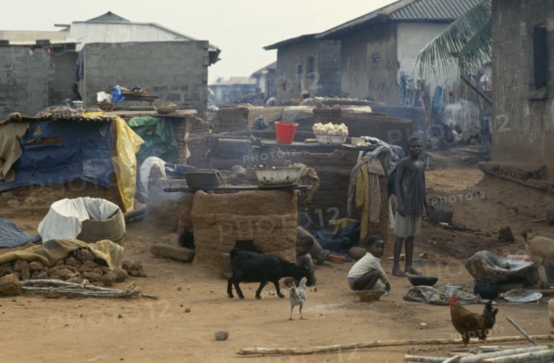 GHANA, Village Scene, "Outside ovens in village near Accra with children, goats and chickens around."