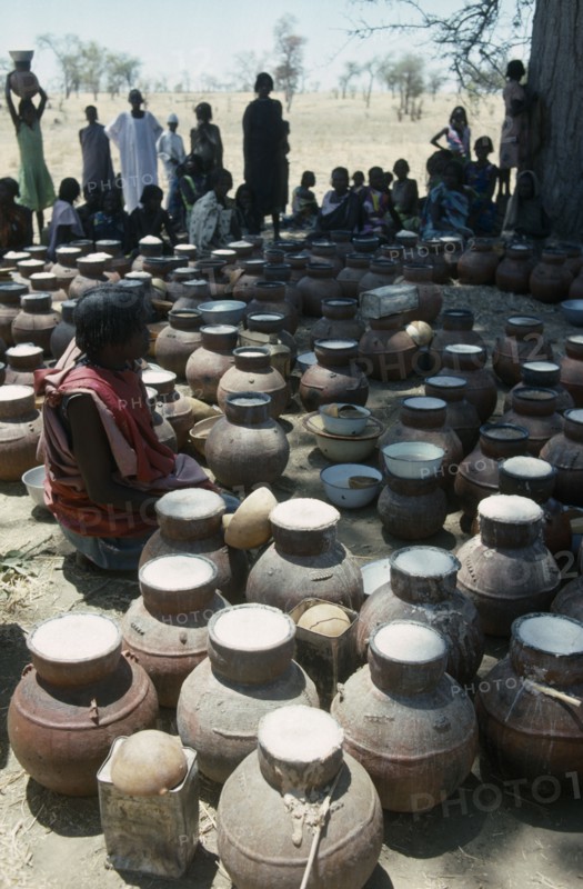 CHAD, Habila, Woman selling vessels of Marissa Beer made from Sorghum and millet at Chadian Refugee market