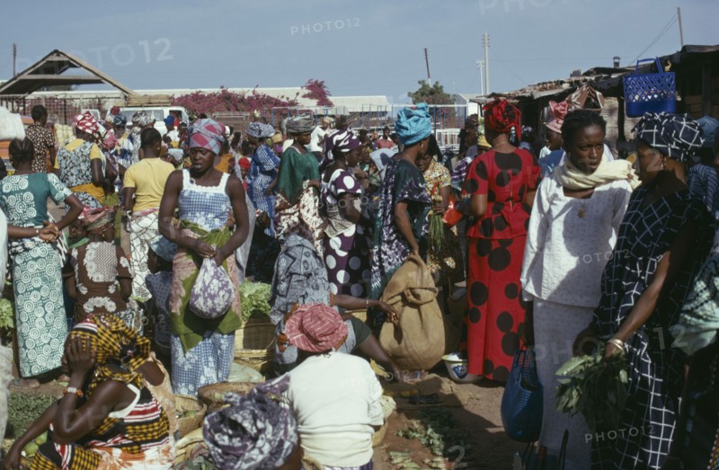 GAMBIA, Banjul, Women at market wearing brightly coloured clothes