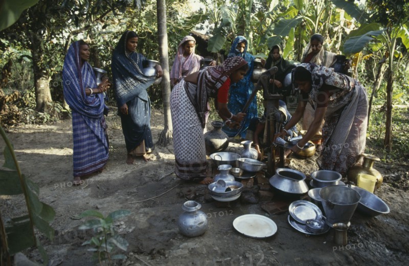 BANGLADESH, Water, Women collecting water at hand pump.