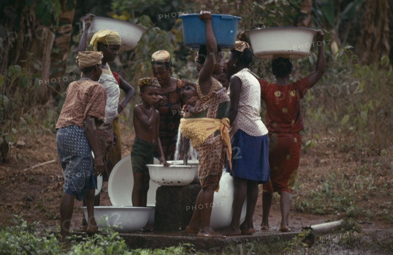 NIGERIA, Mid West State, Women and children collecting water at stand pipe.