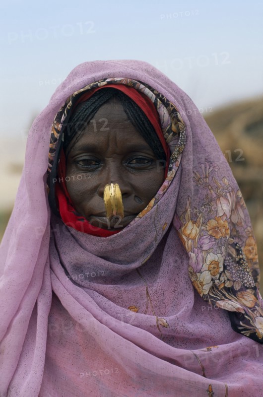SUDAN, North East, Gadem Gafriet Camp, Head and shoulders portrait of Beni Amer nomad refugee woman.