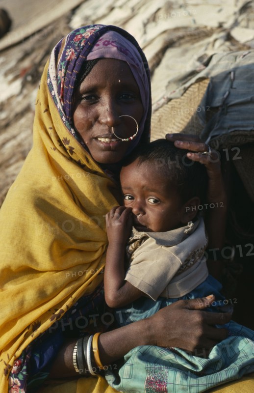 SUDAN, North East, Gadem Gafriet Camp, "Portrait of Beni Amer Beja nomad woman holding child, refugees from Eritrea."