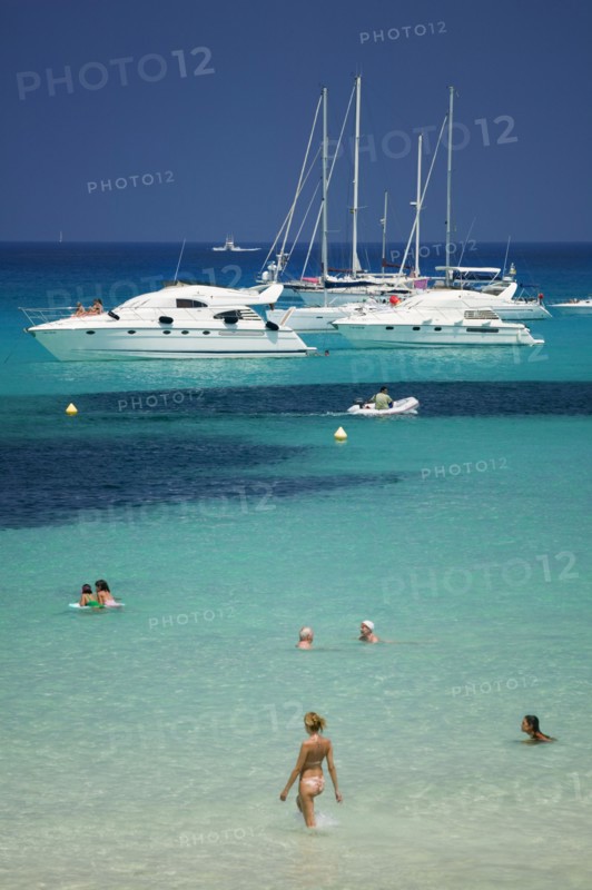 SPAIN, Balearic Islands, Ibiza, "Pleasure boats at Cala Saona, Formentera, with a few people swimming in the sea."