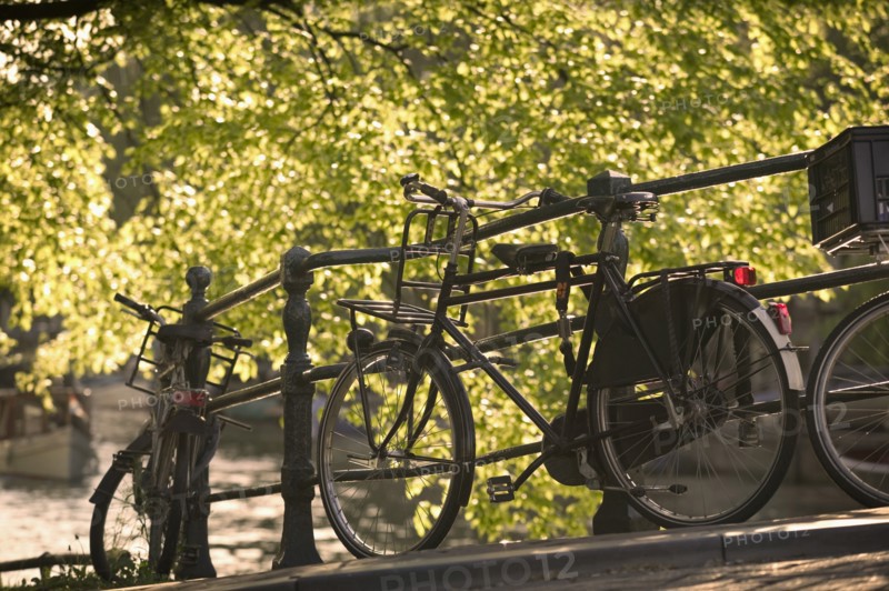 HOLLAND, North , Amsterdam, Bicycles leaning against railings on a city centre bridge.