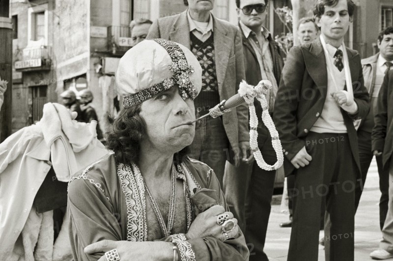 SPAIN, Catalonia, Barcelona, Gypsy sword swallower performing on La Ramblas with crowd watching.