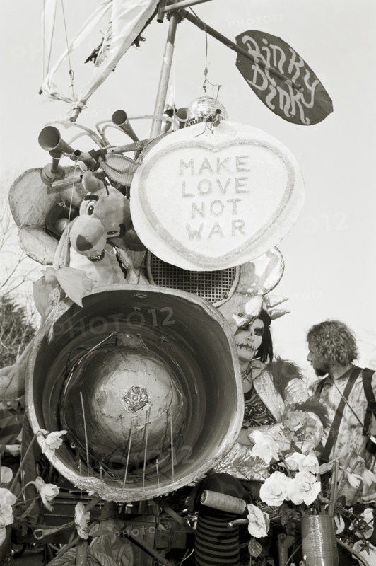 ENGLAND, Gloucestershire, Fairford, The Rinky Dink and peace protesters during an anti-war rally at RAF Fairford. Make love not war poster.
