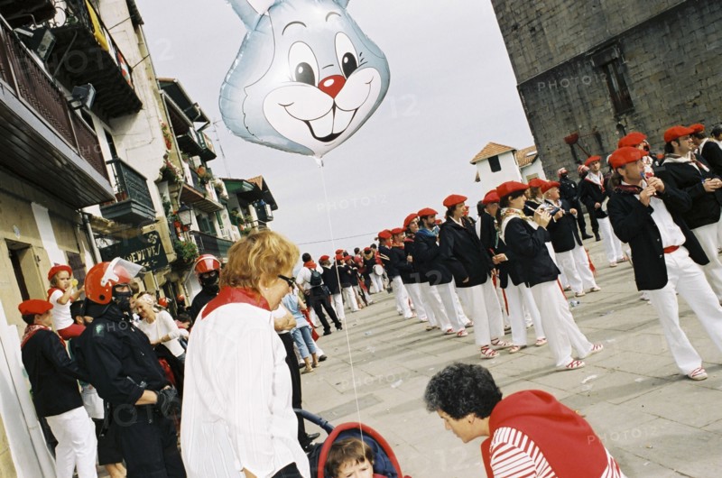SPAIN, Hondarabia, The Basque Country, Basque riot policemen guard Basque suffragette marchers during the Alarde on 8 September. Child in push chair with rabbit balloon.