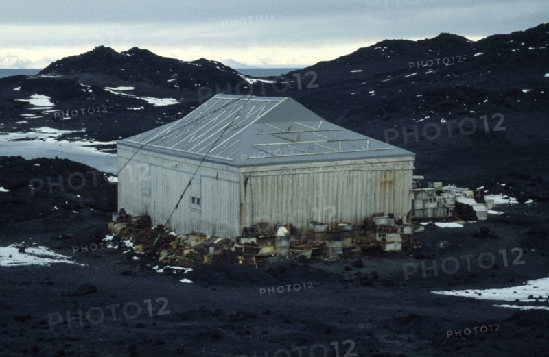 ANTARCTICA, Ross Island, "Shackleton’s Hut at Cape Royds,  with crates stacked around the sides of the weathered wooden building."
