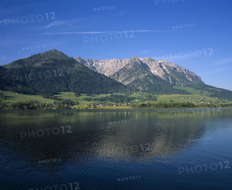 AUSTRIA, Pyramidenspitze, Kaisergebirge Mountains, "East of Kufstein, Zahmer Kaiser. Overlooking lake, houses at the base of the tree covered mountain. Beyond Walchsee."
