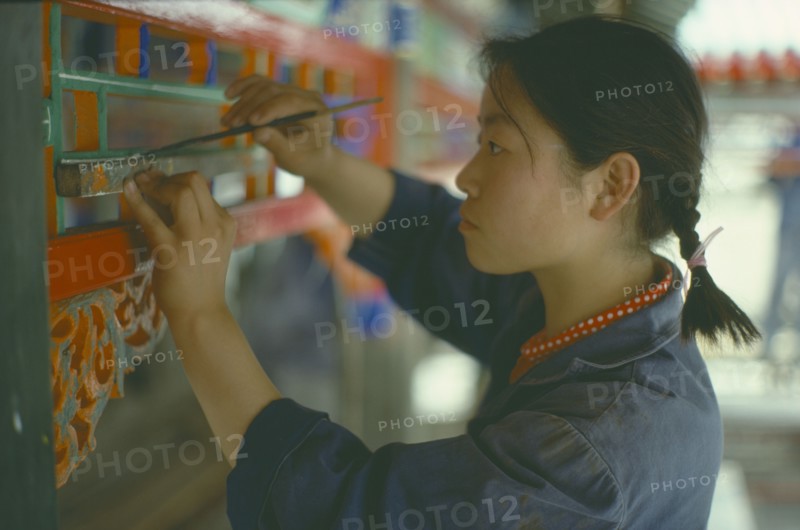 CHINA, Beijing, Young woman undertaking restoration work on the Summer Palace.