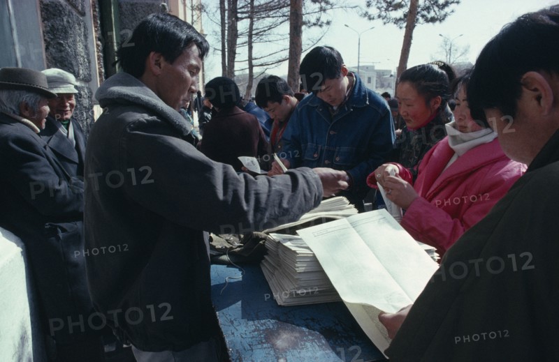 MONGOLIA, Ulaanbaatar, Newspaper vendor and customers.