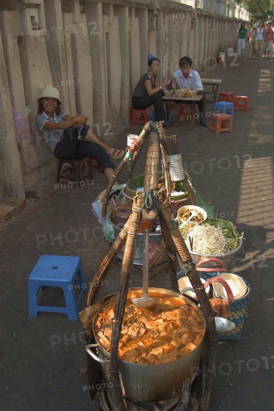 VIETNAM, South, Ho Chi Minh City, Sellers lined up against a wall selling food being from the street