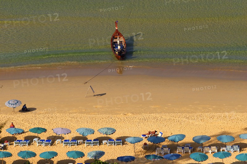 THAILAND, Phuket, Karen Beach, Sun umbrellars on golden sandy beach with boat at shoreline.