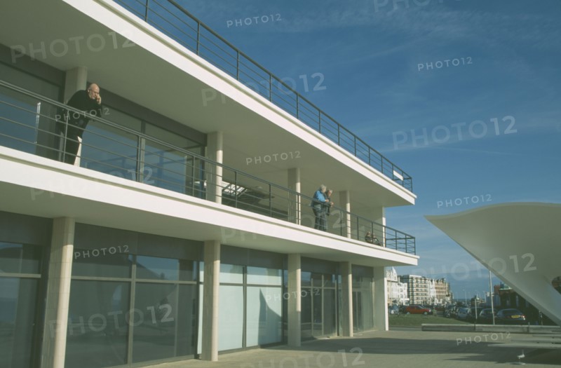 ENGLAND, East Sussex, Bexhill on Sea, De La Warr Pavilion. Exterior view of visitors on balcony terrace and corner of bandstand.