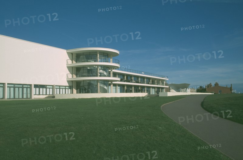 ENGLAND, East Sussex, Bexhill on Sea, De La Warr Pavilion. Exterior view over grass towards back entrance with staircase section and terracing.