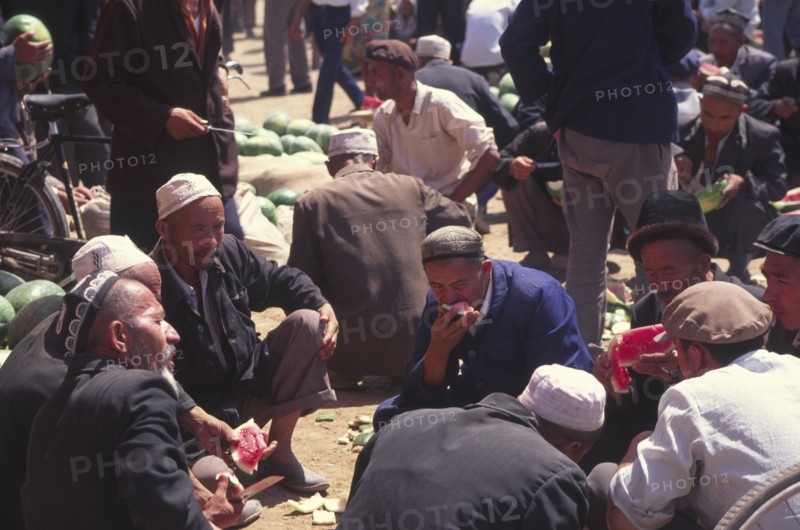 CHINA, Xinjiang Province, Kashgar, Market Vendors eating water melon