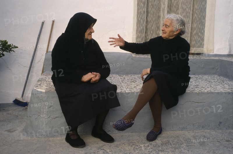 SPAIN, Andalucia, Two elderly ladies in conversation in village street.
