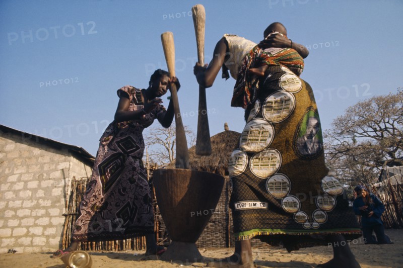 SENEGAL, Agriculture, "Women pounding maize, one carrying baby on her back."