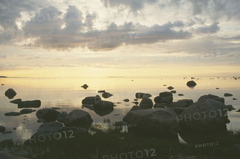ESTONIA, Baltic Coast, Sunset over rocks and sea during the longest day of the year.