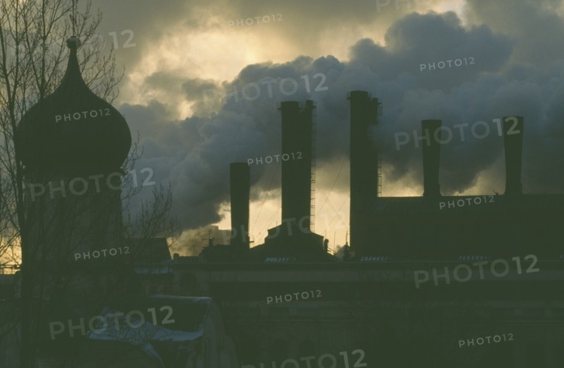 RUSSIA, Moscow, Onion dome roof of the Kremlin with smoke billowing from power station chimneys behind.