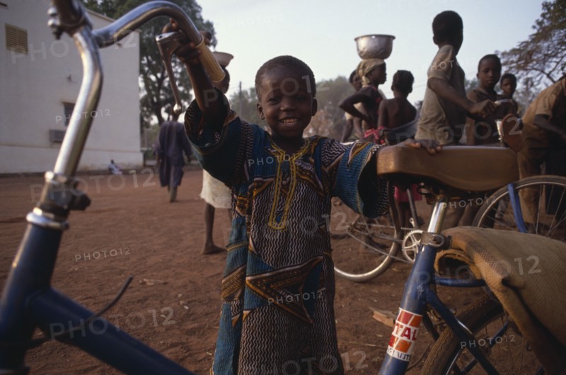 MALI, Sikasso, Little boy with bicycle.