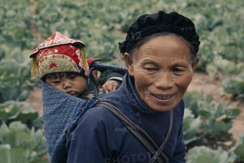CHINA, Children, Carrying, Woman from Miao minority people carrying child on her back in papoose.