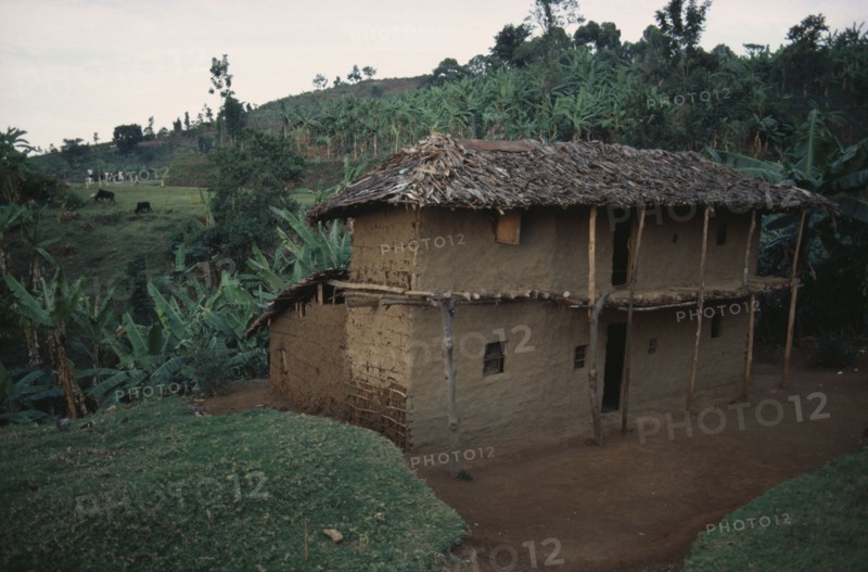 UGANDA, Traditional Housing, Two storey mud brick house with thatched roof in rural area near Mbale.