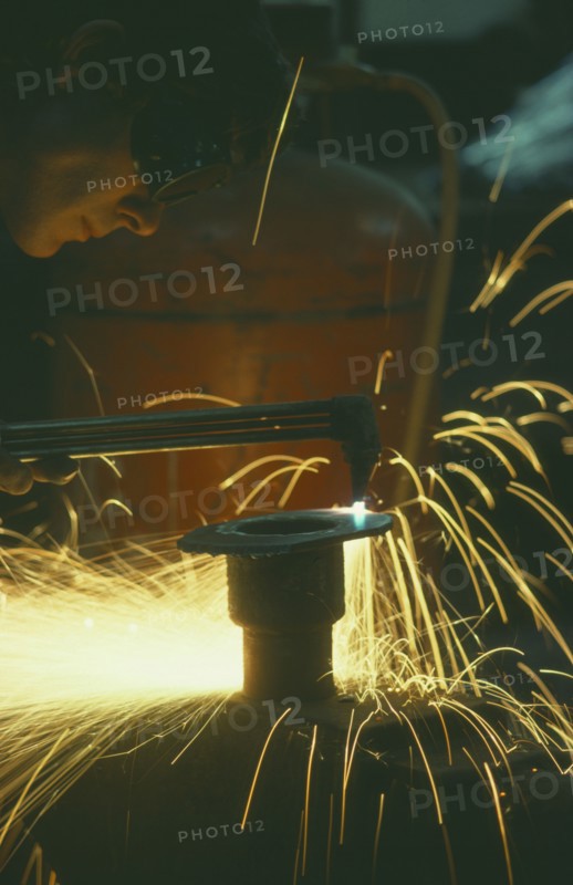 ENGLAND, Dorset, Engineering, Man wearing protective goggles while welding with sparks flying.