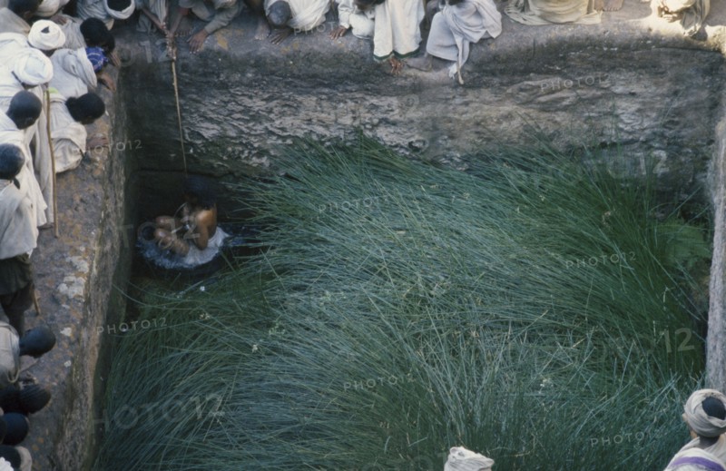 ETHIOPIA, Lalibela, Girl immersed in pool to increase fertility.