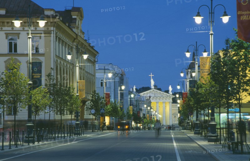 LITHUANIA, Vilnius, Gedimino shopping street lined with illuminated street lights leading to the Cathedral at night.